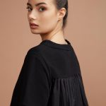 Maglia dal taglio lineare, realizzata in puro cotone organico, presenta sul retro un plissè che la rende morbida e comoda